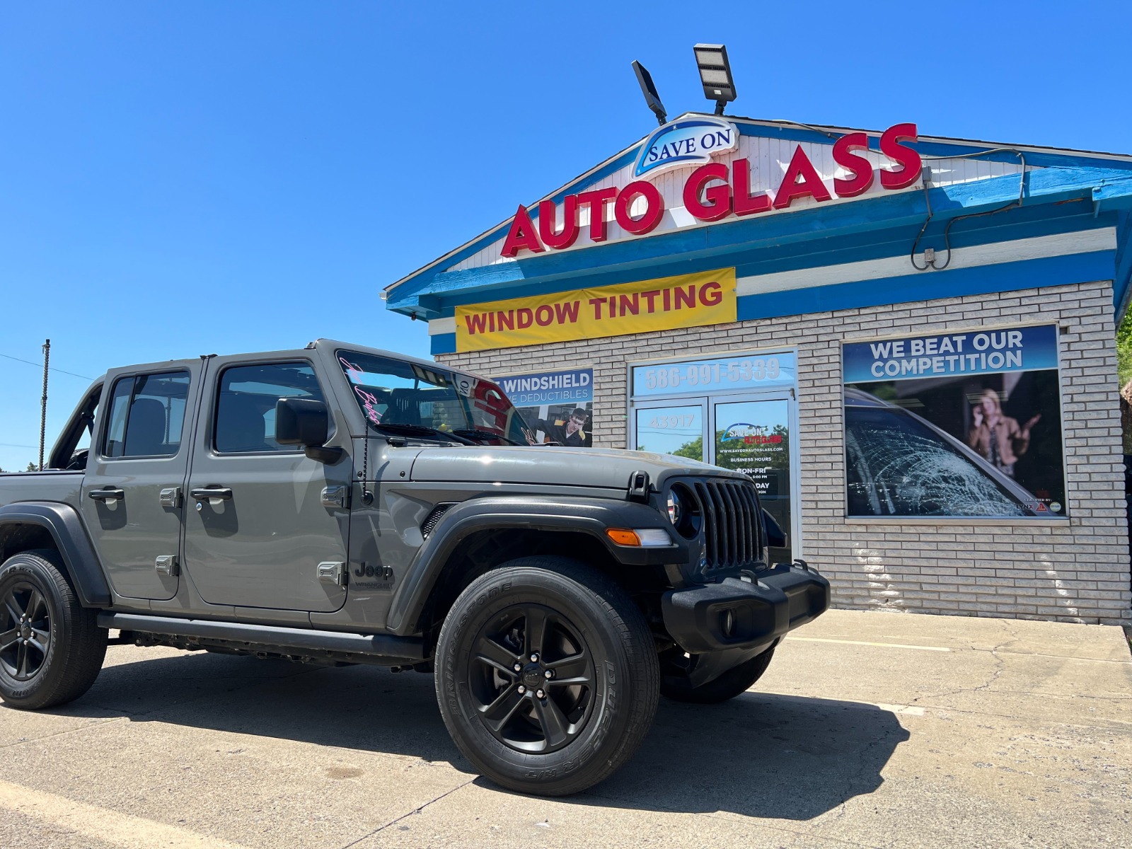 Gray SUV parked in front of the Save On Auto Glass storefront after completed auto glass service